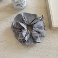 Detailed view of large navy striped scrunchie with branded woven label on a textured surface - Black Stripe