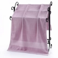 Absorbent light purple cotton bath towel with honeycomb weave trim hanging on a black rack - Rice Grid Jacquard Bath Towel (Light Purple) / 70*140cm