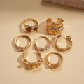 Dettaglio del set di 7 anelli dorati con texture lava, pietre ambrate e perle bianche - Oro (Set da 7 pezzi)