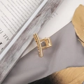 Elegant gold metal small hair claw clip with square hollow design on soft gray fabric - Small Gold Simple Square