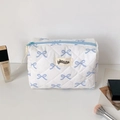 Detalle de neceser acolchado blanco con estampado de lazos azules y cierre de cremallera - Lazo Azul