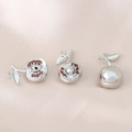 Détail macro du pendentif pomme en argent avec cristaux rouges sur soie rose douce - Argent (Pomme)