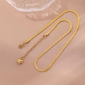 Minimalist gold stainless steel snake chain necklace with heart pendant on pink background - Gold