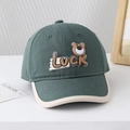 Détail de la casquette baseball en coton vert foncé avec écusson ours Luck et bord crème - 50cm (1-3 ans) / Ours Luck-Vert