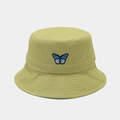 Dettaglio del ricamo a farfalla blu sul cappello a secchiello verde chiaro con cuciture fini - Verde