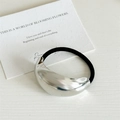 Minimalist black elastic hair tie with a polished silver-finish metallic arc ornament - Semi-oval / Silver