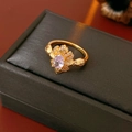 Nahaufnahme eines Vintage-Goldrings mit lila Zirkon auf einer schwarzen Schmuckschatulle - Vintage Blumen Stil / Gold (Lila Stein)