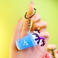 Blue tea cup keychain with mini donuts and purple topping in a hand-held view - Metal Chain Style / Blue (Chain Style, No Package)