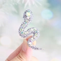 Silver snake brooch with AB rhinestones held in hand with soft bokeh background - Light Powder Blue