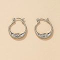 Silver retro hoop earrings with delicate moon relief design on a beige background - Silver