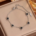 Pulsera de acero inoxidable plateada con cinco dijes de corazones negros y cierre - Color Acero Circón Negro