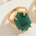 Close-up of a large green hexagonal gemstone ring with gold band and pave diamonds - Emerald Green Hexagon