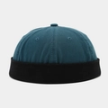 Detail of teal and black patchwork cotton docker hat showing twill texture and eyelets - Blue Black Edge