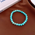 Dettaglio del bracciale di perle turchesi neo-cinesi con texture naturale su fondo scuro - 6mm / Blu