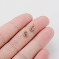 Oval gold-plated pendant with purple zircon gemstone inlay shown on fingers - Purple Zirconia Oval