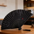 Classic black folding fan with white willow leaf pattern, red seal, and black silk tassel - Black Willow Seal