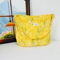 Detail of yellow floral canvas shoulder bag with small white flowers and text label - Yellow Flower