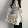 Dettaglio del ricamo e delle illustrazioni colorate sulla borsa tote in tela bianco avorio - Ricamo Colorato / Beige