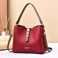 Elegant red leather handbag with gold buckle and adjustable strap in professional studio - Burgundy