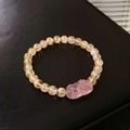 Detail of yellow crystal beaded bracelet featuring a pink carved Pixiu gemstone centerpiece - 4# Strawberry Quartz Pixiu