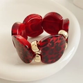 Detalle de eslabones de resina con estampado de leopardo rojo y conectores dorados - Rosa Rojo