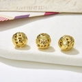 Macro shot of three vintage hollow gold metal beads with detailed relief patterns for DIY jewelry - Style 9