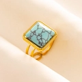 Macro view of adjustable golden steel ring with square turquoise stone and beaded trim - Gold/Light Blue Turquoise