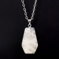 Macro detail of natural clear crystal coffin pendant with silver chain on black velvet - White Crystal