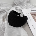 Detail of a black pleated wide headband with bow accents on a stylish magazine background - Black