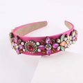 Detail eines rosenrosa Satin Stirnbands mit bunten Strasssteinen und Blumenmustern - Rosenrosa