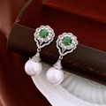 Detalle de pendientes vintage con gema verde, baño de plata y perlas blancas elegantes - Plateado