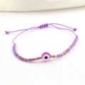 Close-up of purple woven evil eye bracelet with golden beads and adjustable sliding knot - Type G-Purple Evil Eye