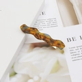 Detail of wavy acetate hair clip with tortoise shell pattern and gold metal spring clip - Amber Tortoiseshell