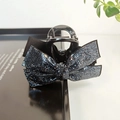 Close-up of black rhinestone butterfly hair claw clip on a sleek reflective surface - Navy Blue Rhinestone