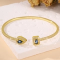 Detail of adjustable gold bangle with blue teardrop and rectangular gemstones - Gold Blue