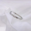 Minimalist silver titanium steel bangle with geometric checkerboard pattern on white silk - Steel