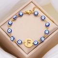 Bracciale occhio portafortuna dorato con perline blu e ciondolo centrale lettera F - Lettera F