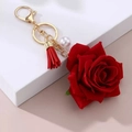 Red rose keychain with gold chain, crimson tassel and white pearl pendant on white base - Red