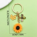 Golden sunflower bee and honeycomb keychain with pearls and crystals on green background - Honeycomb Rhinestone Sunflower