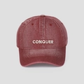 Detailed close-up of dark red washed denim baseball cap with white Conquer embroidery - M (56-58cm) / Red