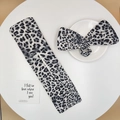 Detail of grey leopard print hair bun maker and matching bow headband on a white plate - Grey Small Leopard