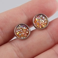 Macro view of 8mm orange glitter stainless steel stud earring held on a fingertip - Orange (10)
