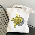 White canvas tote bag with Sun and Moon artistic print shown on a black mesh chair - STD438-D (Yellow Face Sun and Grey Moon)
