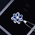 Detailed view of a silver flower pendant necklace with blue and clear zircon crystals - Pendant Only (No Chain)