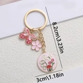 Portachiavi con farfalla rosa e ciondolo a fiore in finitura dorata con dimensioni - Farfalla Rosa e Fiore