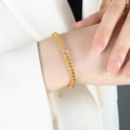 Elegant gold beaded bracelet with a sparkling clear zircon stone worn on a female wrist - Bracelet (14+5cm) / Gold