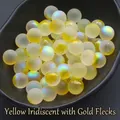 Detail of 12mm frosted yellow glass beads with gold dust and iridescent finish in a tray - 12mm Holeless / Iridescent Yellow