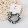 Detail shot of grey faux pearl elastic hair tie with metallic finish on handmade card - Card Packaging / Gray