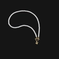Dettaglio ravvicinato della collana di perle con chiusura a barra dorata e pendente M - Lettera E in Acciaio Inossidabile Dorato