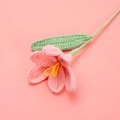 Detailed close-up of a handmade pink crochet tulip flower with green stem and yellow pistil - Finished Open Tulip Bouquet (korean Pink)